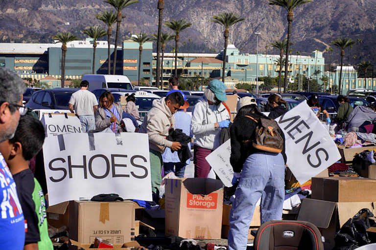 People sort through bins labeled 'mens' and 'womens' and 'shoes.'