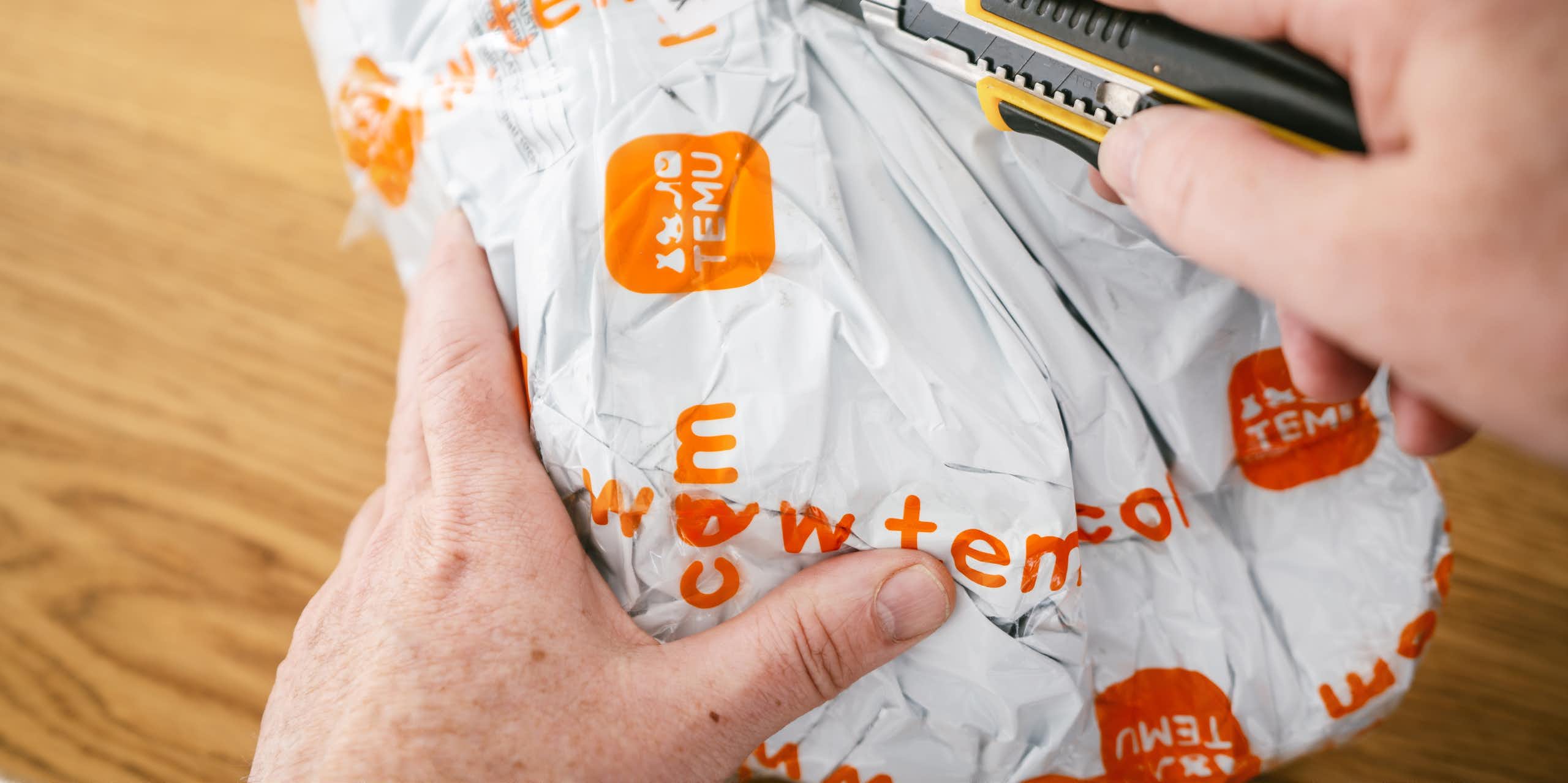 une personne ouvre un colis temu avec un cutter