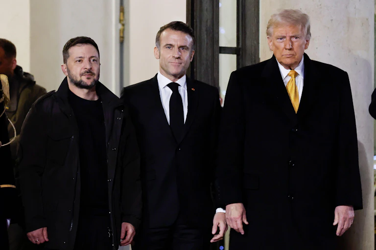 Donald Trump meets President Macron (middle) and President Zelensky (left) standing next to each other.