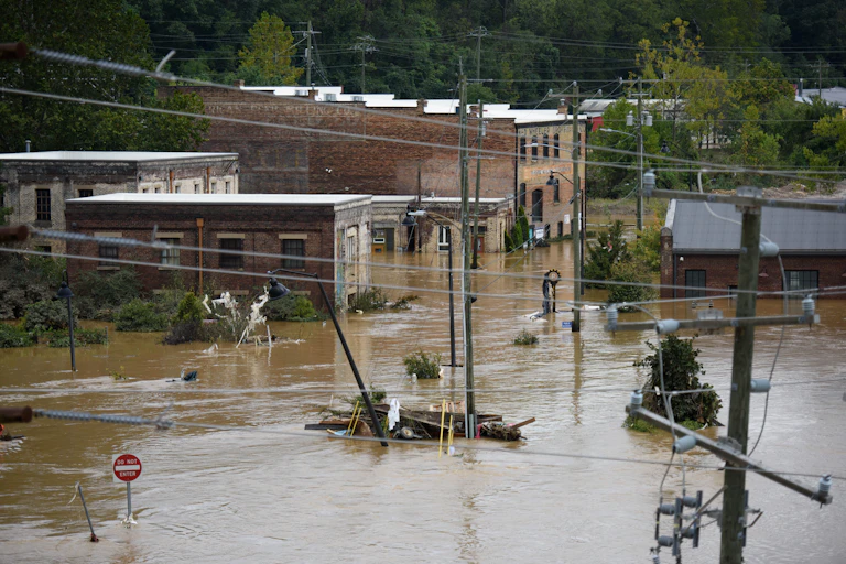 brown flood water covers an intersection with partially flooded brick buildings in the background