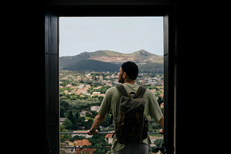 Man standing on balcony alone looking at a landscape