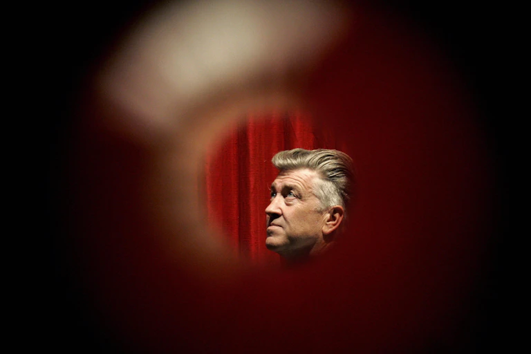 Headshot of man with silver, wavy hair through a peephole.