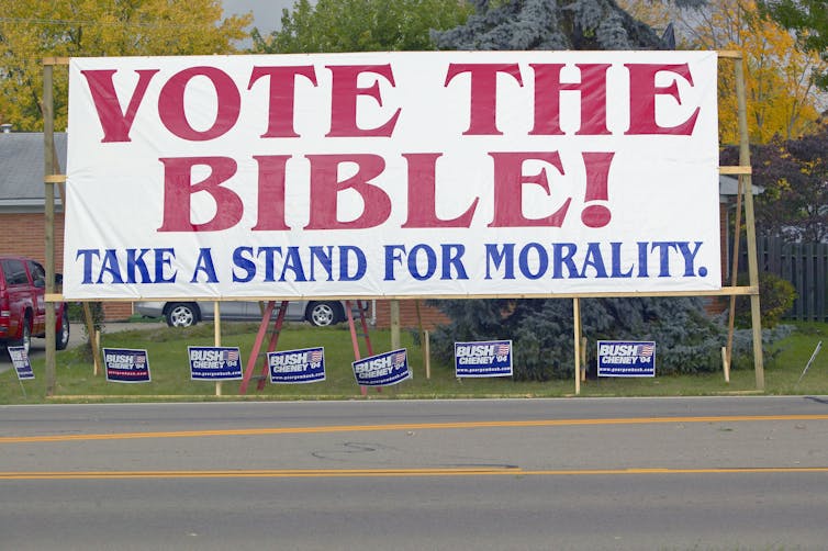 A large campaign poster that says, 'Vote The Bible! Take a Stand for Morality.