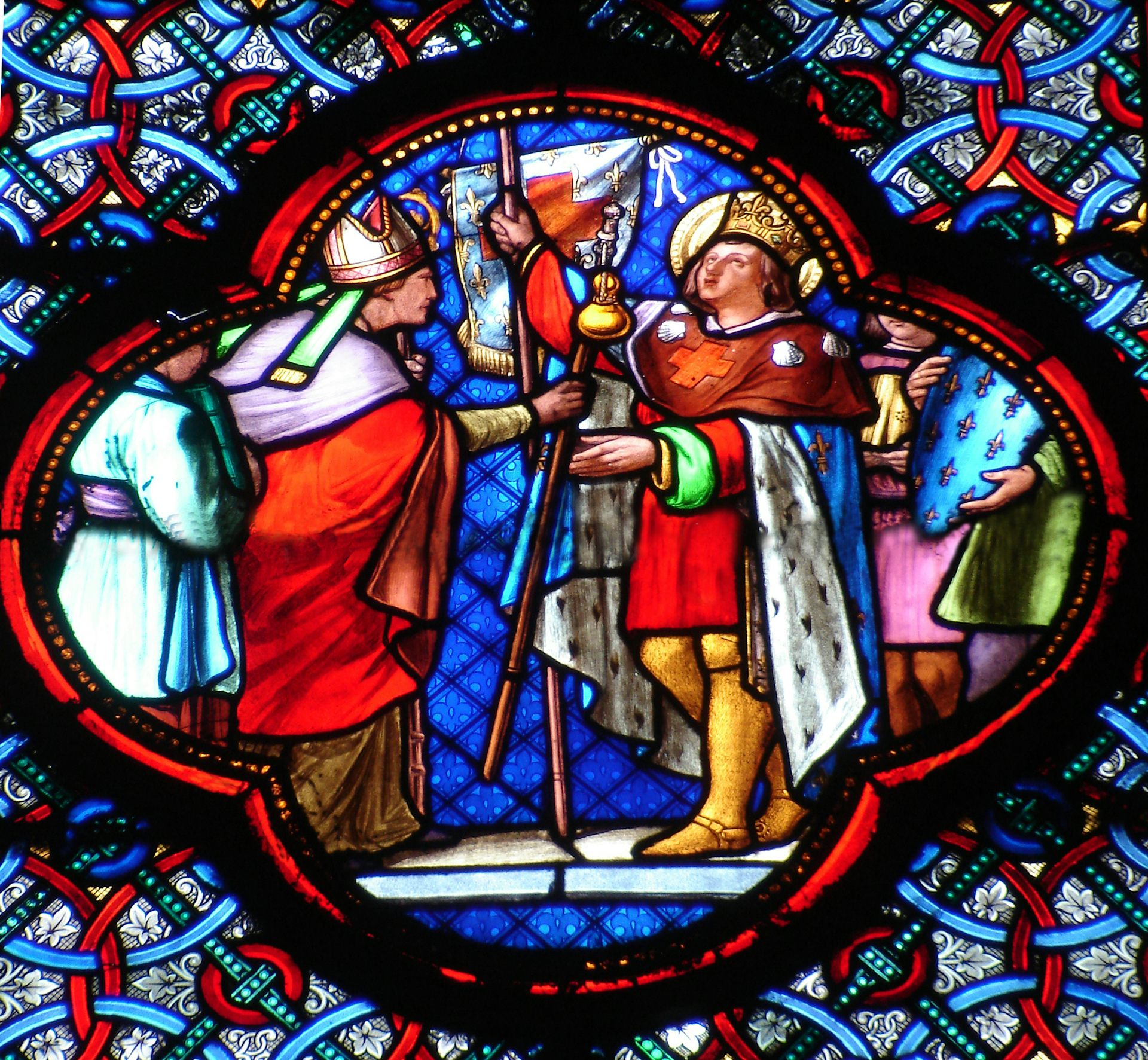 A stained glass window depicts two men, each holding a staff, with one gazing up at the sky.