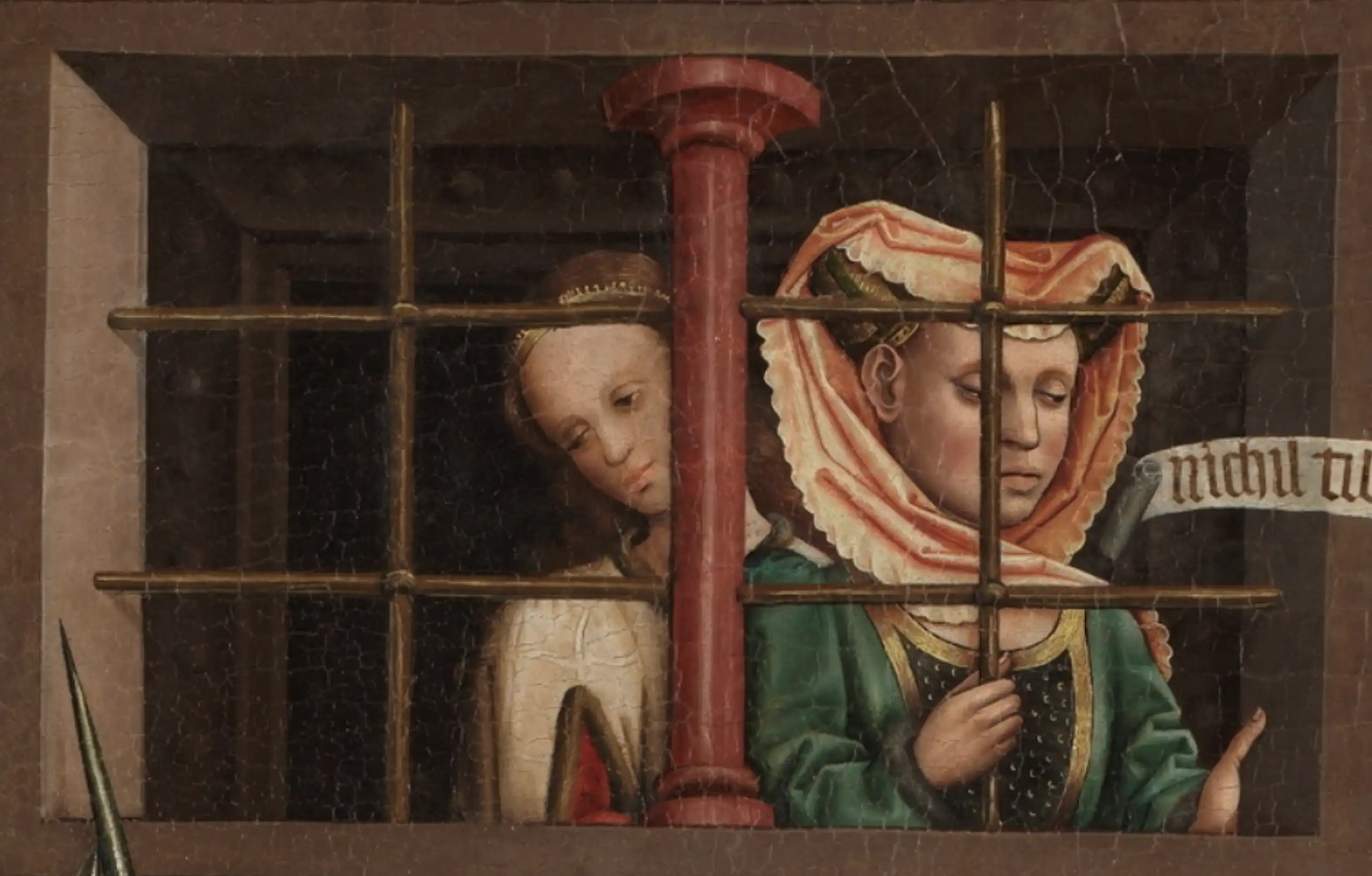 Una mujer observa detrás de una ventana enrejada.