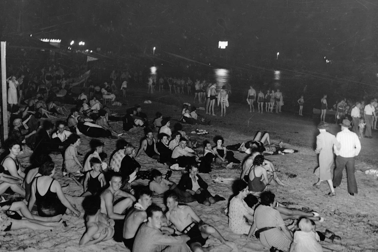 A beach in Glenelg, South Australia is packed during an evening in February 1938.