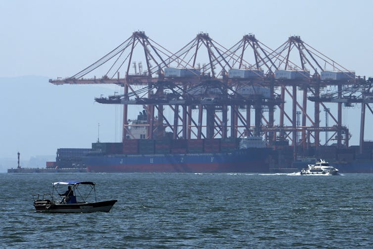Boats in front of a container vessel.