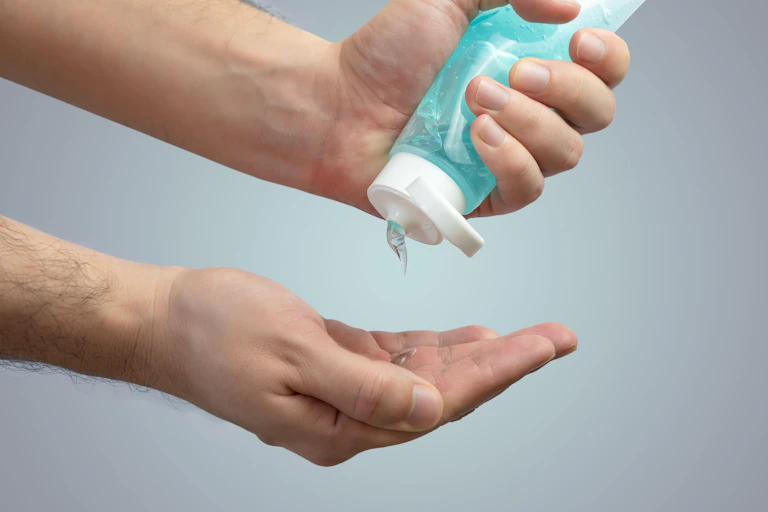 A man squeezes gel onto his hand.