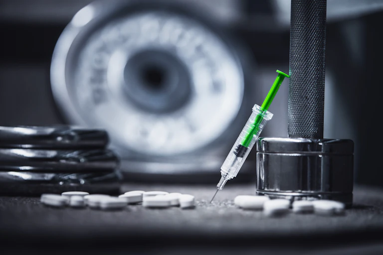 A syringe and tablets are shown at a gym