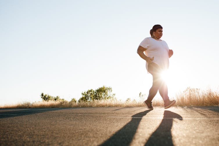 The woman is running on the road.