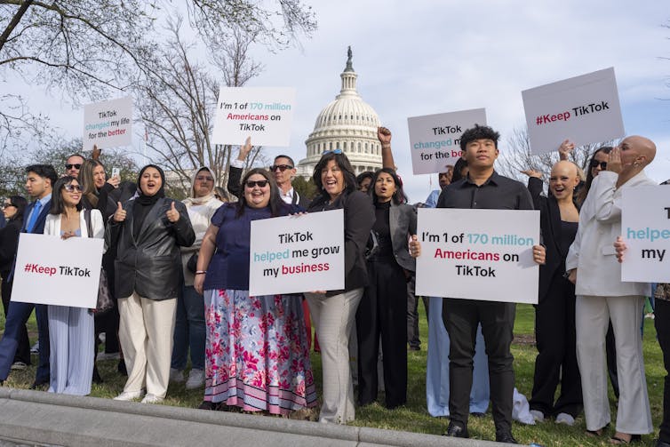 A diverse group of people holding up various placards in support of TikTok.