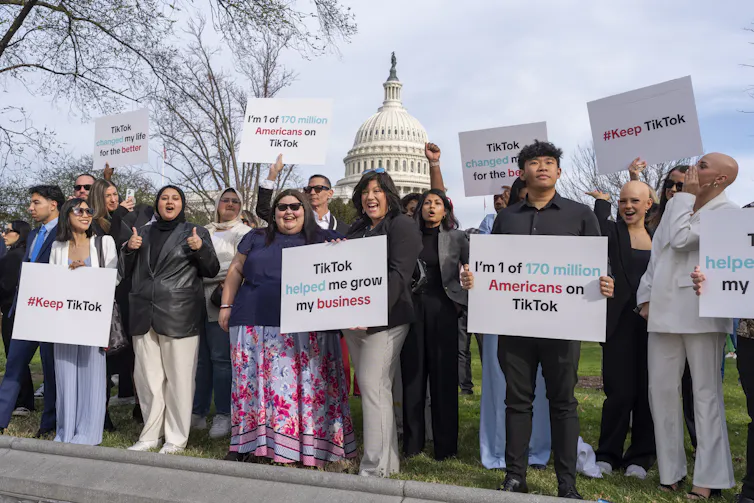 A diverse group of people holding up various placards in support of TikTok.