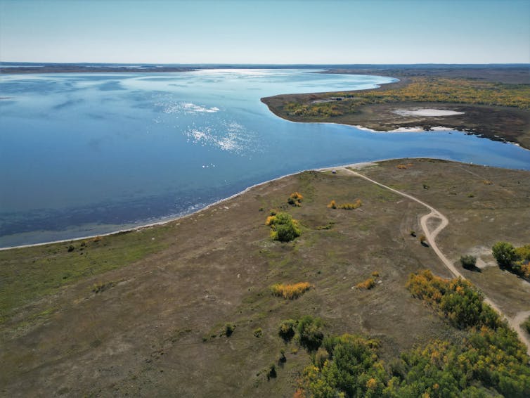 une vue à vol d’oiseau d’un grand lac entouré d’un terrain plat et sec