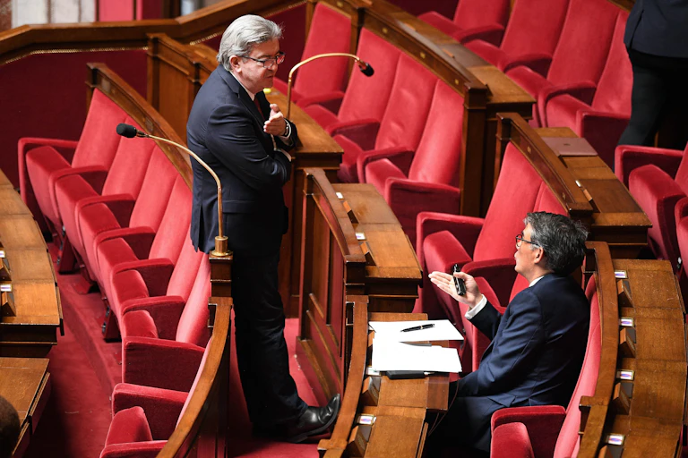 Jean-Luc Mélenchon et Olivier Faure discutant sur les bancs de l'Assemblée nationale en 2020.