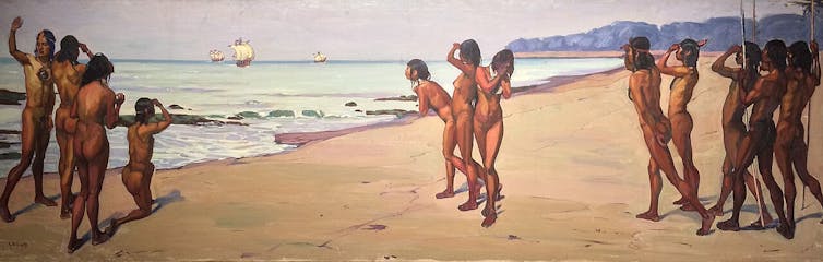 Un grupo de nativos medio desnudos observan desde la playa la llegada de barcos a lo lejos.