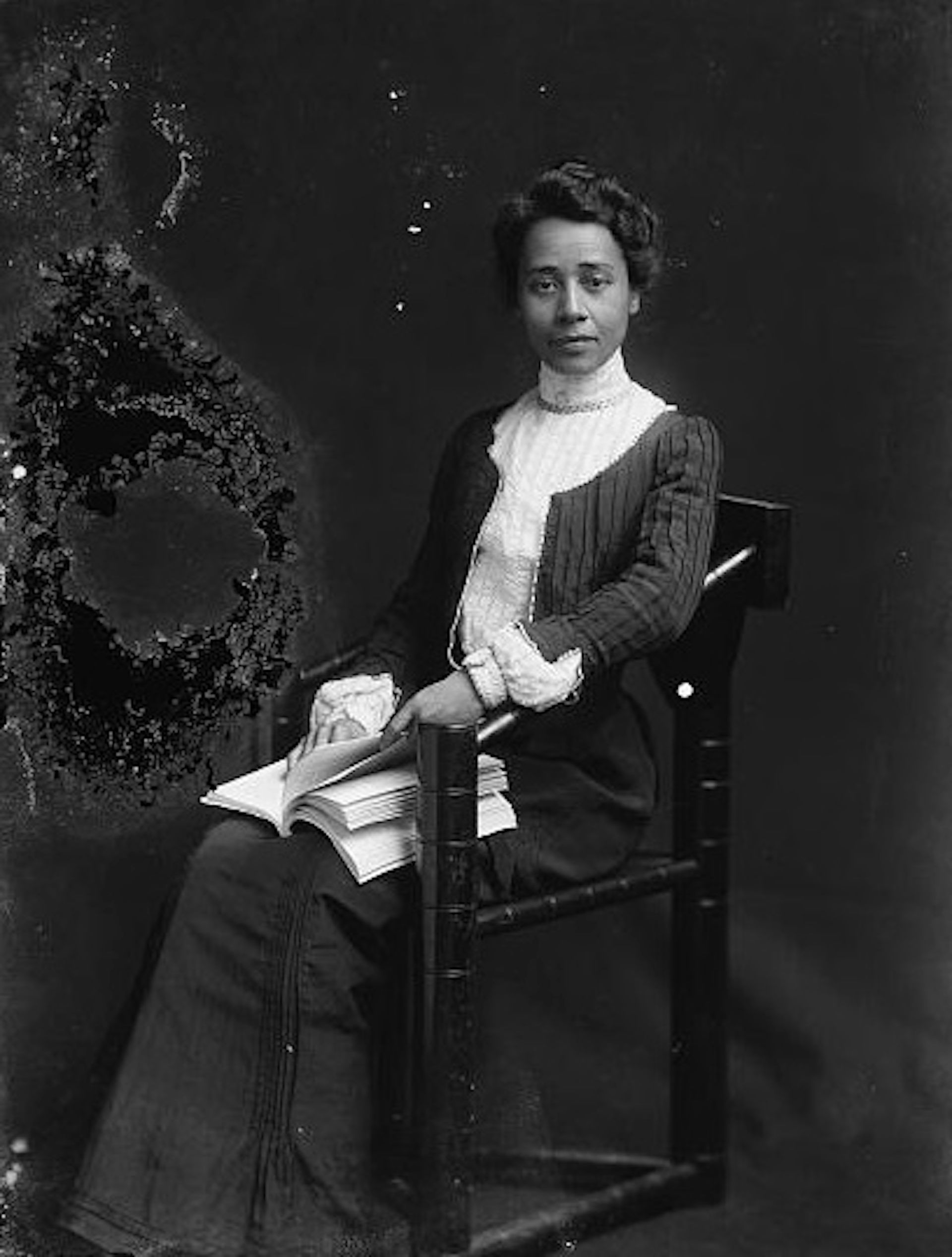 La mujer se sentó sosteniendo el libro.