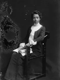 Woman seated holding book.