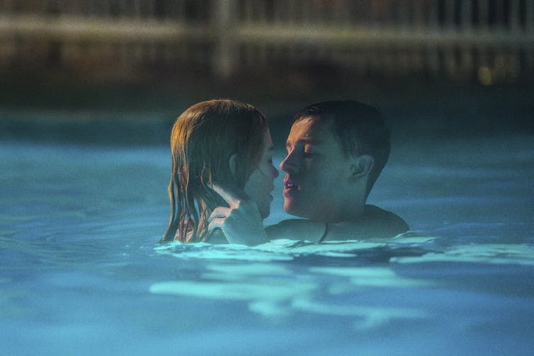 A man and woman embrace in a swimming pool