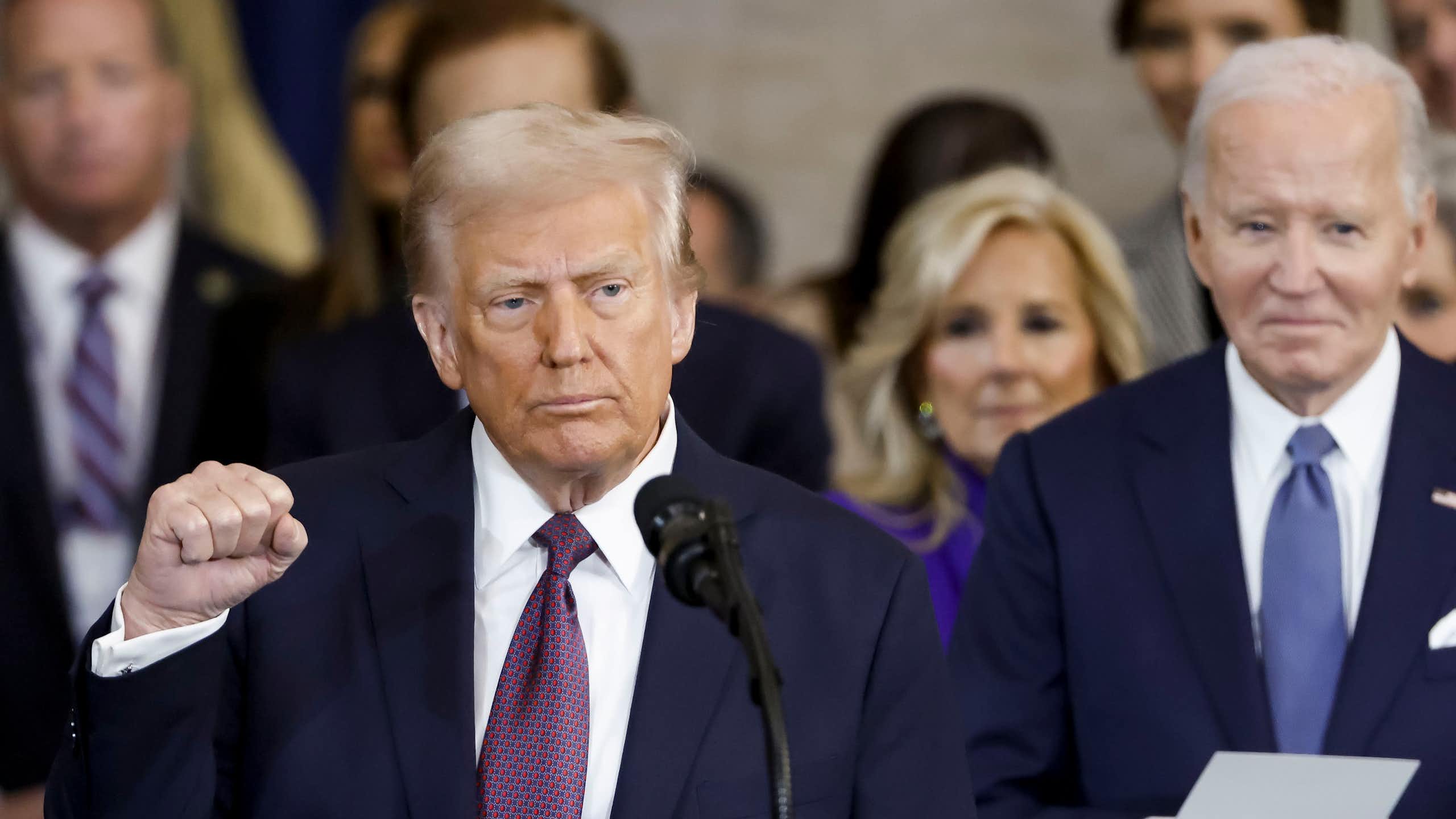 Donald Trump acknowledging the crowd following his inauguration with Joe Biden looking on.