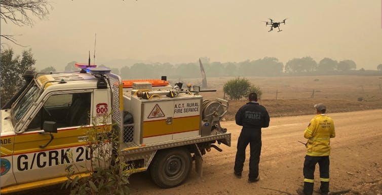 two men and fire truck with drone in smoky conditions