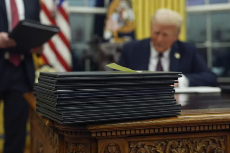 President Donald Trump signs executive orders in the Oval Office of the White House
