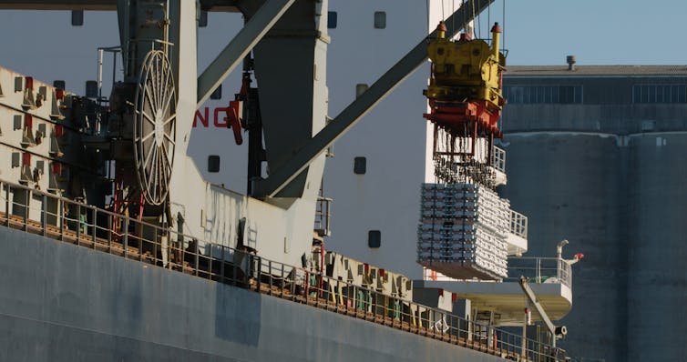 aluminium ingots being loaded onto a container ship.
