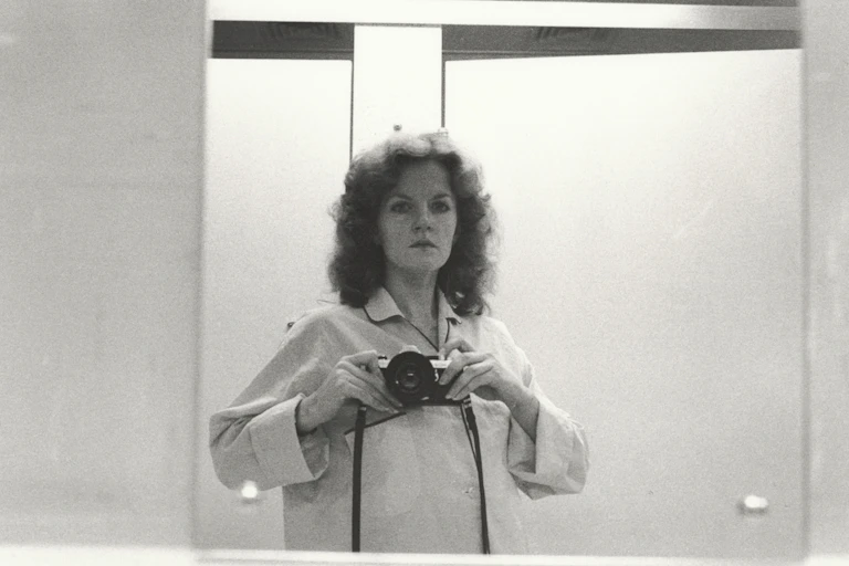 A woman take a photo in a mirror.