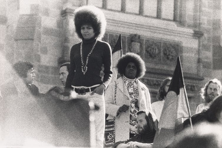 A woman speaks to a crowd.