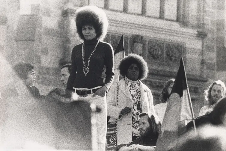 A woman speaks to a crowd.
