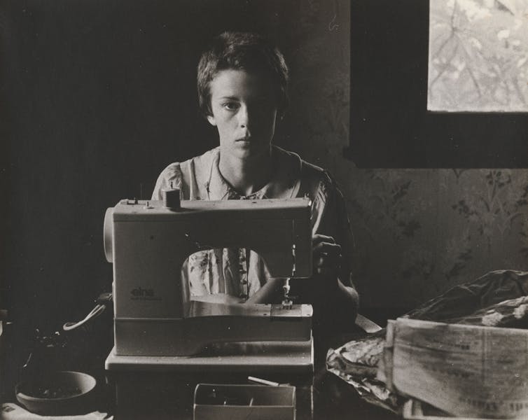 A woman at a sewing machine.