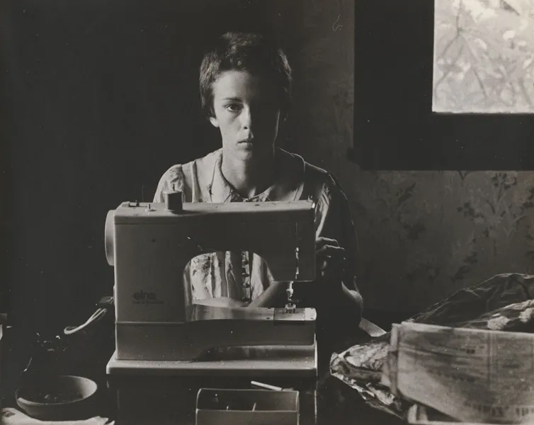 A woman at a sewing machine.