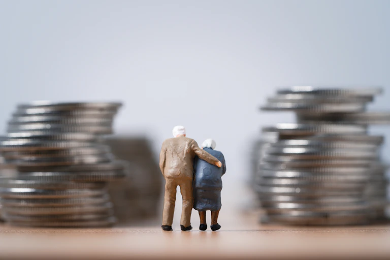 Deux figurines représentant un couple âgé entre deux colonnes de pièces de monnaie