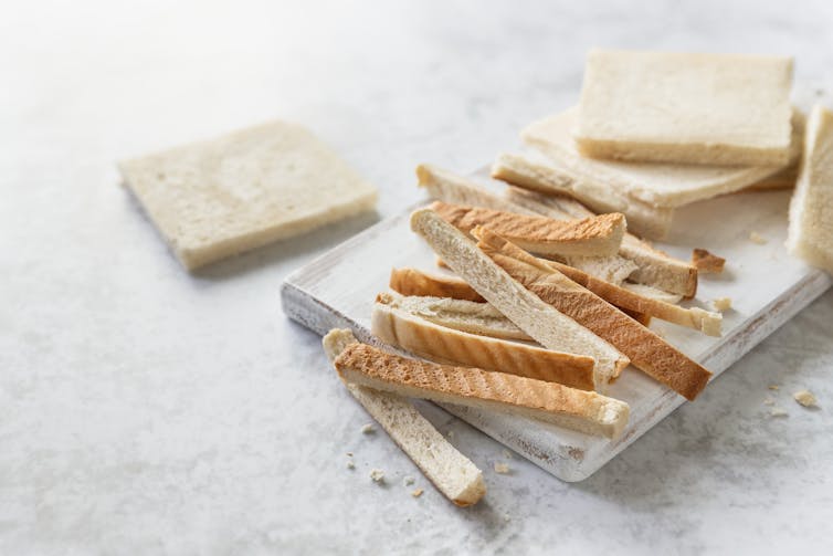 Bread crust stripes on a white wooden board.
