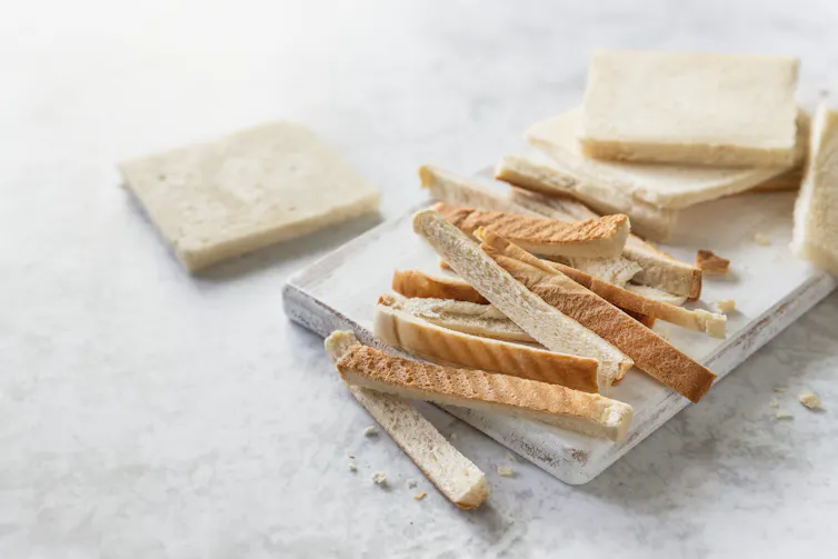 Bread crust stripes on a white wooden board.