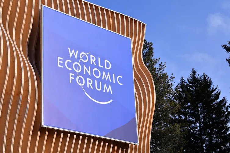 Blue sign on brown building, World Economic Forum
