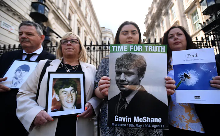 Families holding photos of people who died in the Troubles.