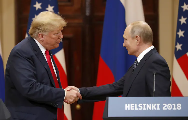 Donald Trump shakes hands with Vladimir Putin