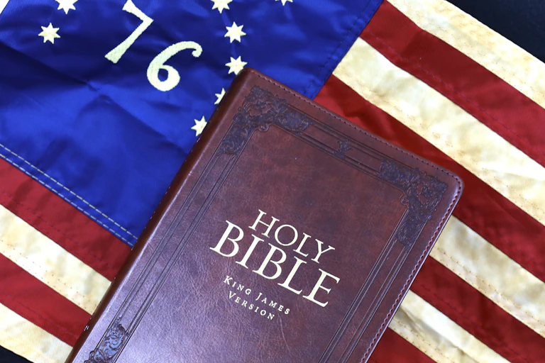 A copy of the King James version of the Bible rests on top of the American flag.