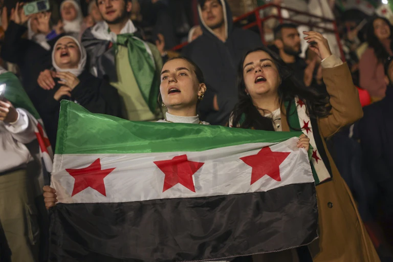 Two women hold a flag.
