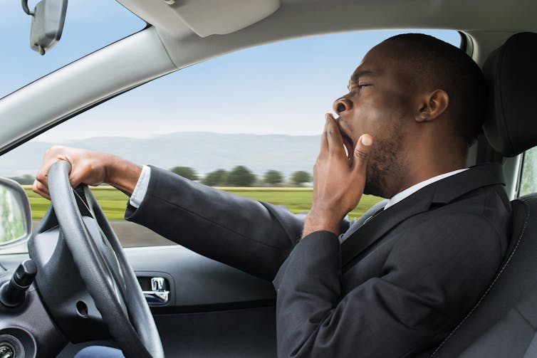 man driving while yawning