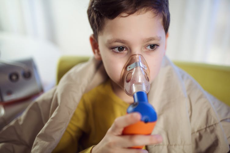 A child using an inhaler.