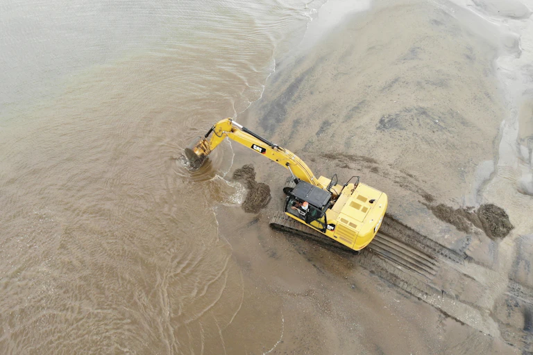 An excavator dredges sea sand in Lhokseumawe, Sumatra.