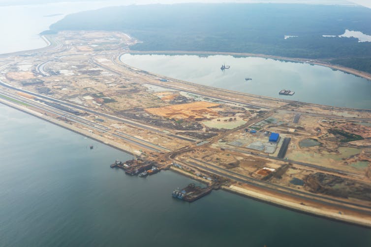 a land reclamation project in Singapore seen from above. sea surrounding sand barges.