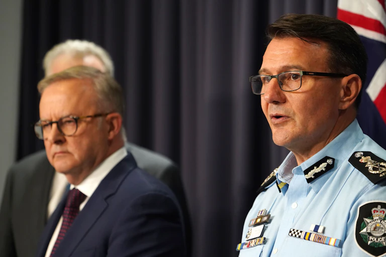 Anthony Albanese stands next to the Australian Federal Police Commissioner