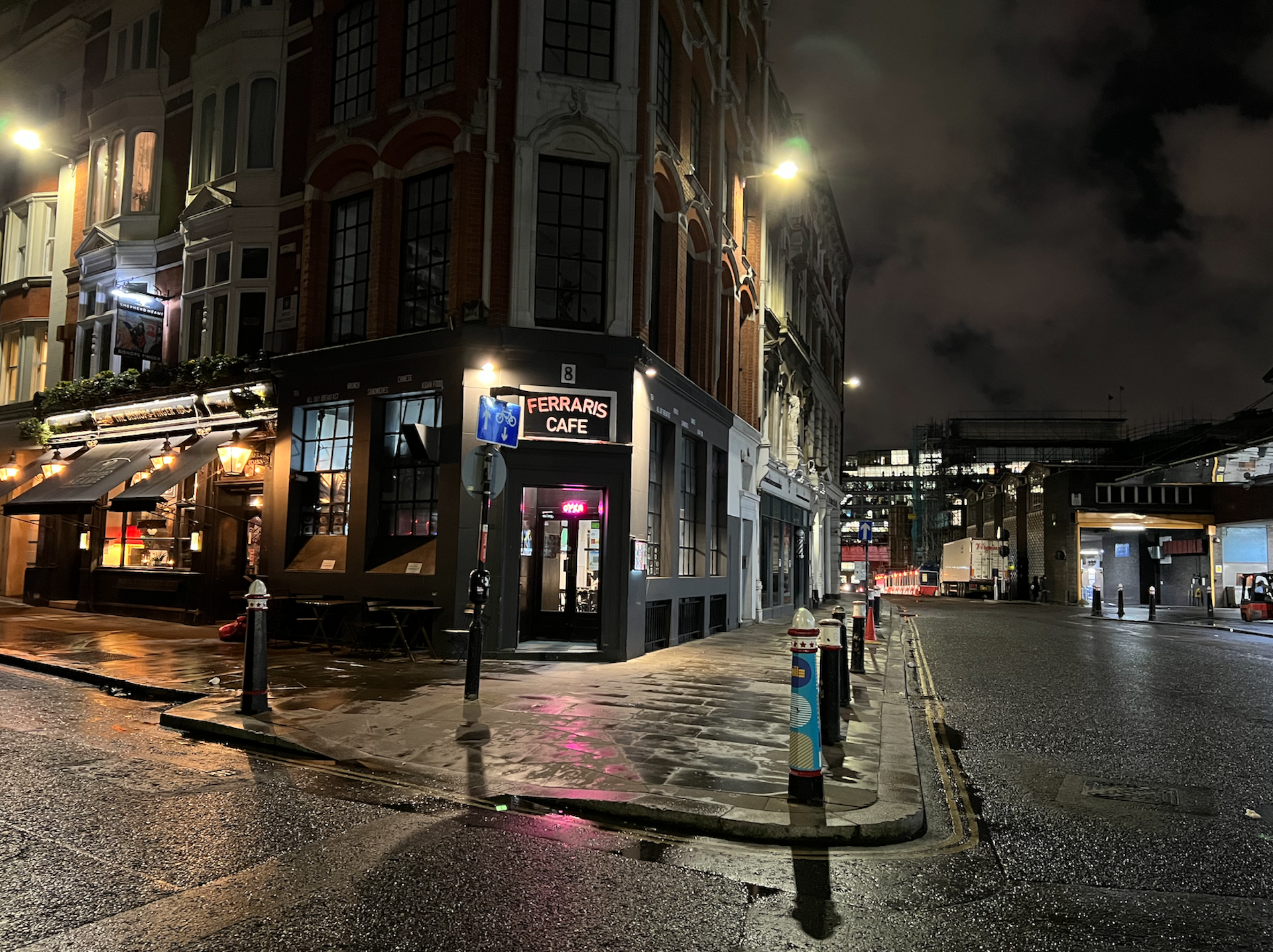 A corner cafe on a London street at night.