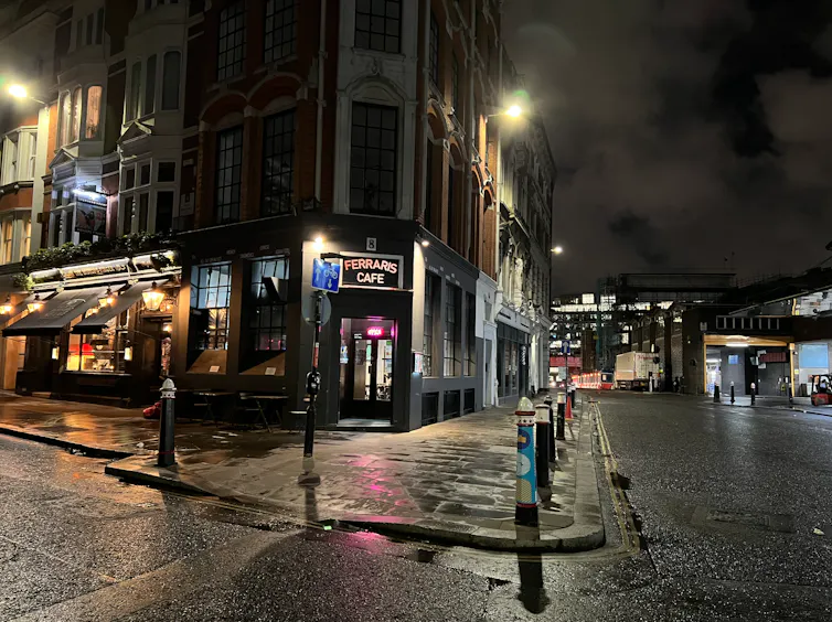 A corner cafe on a London street at night.