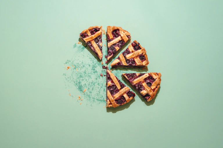 Homemade blueberry cake top view. Slices of delicious blueberries pie on a green background.