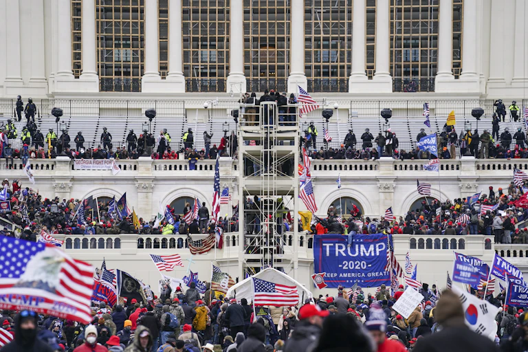 A crowd surrounds the U.S. Capitol building.