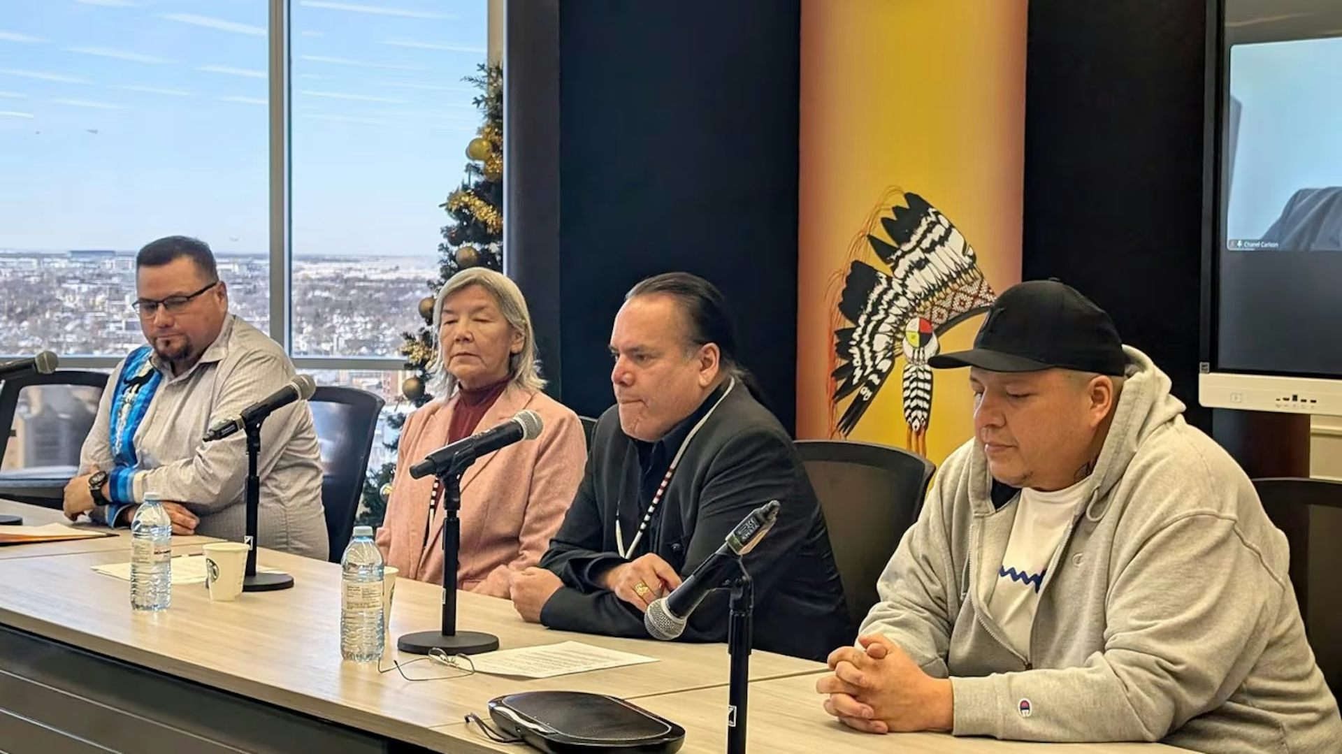 a desk with four people and microphones