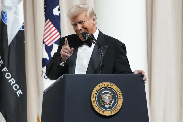 man on lectern points finger
